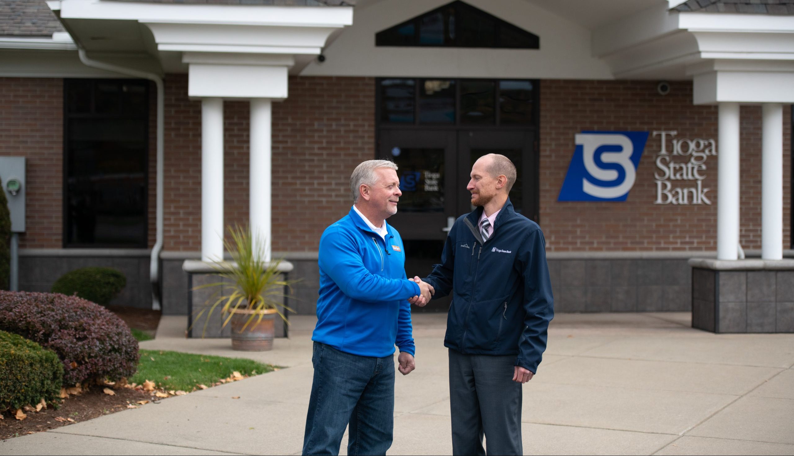Jon Ward shaking hands with Mike Butler in front of TSB
