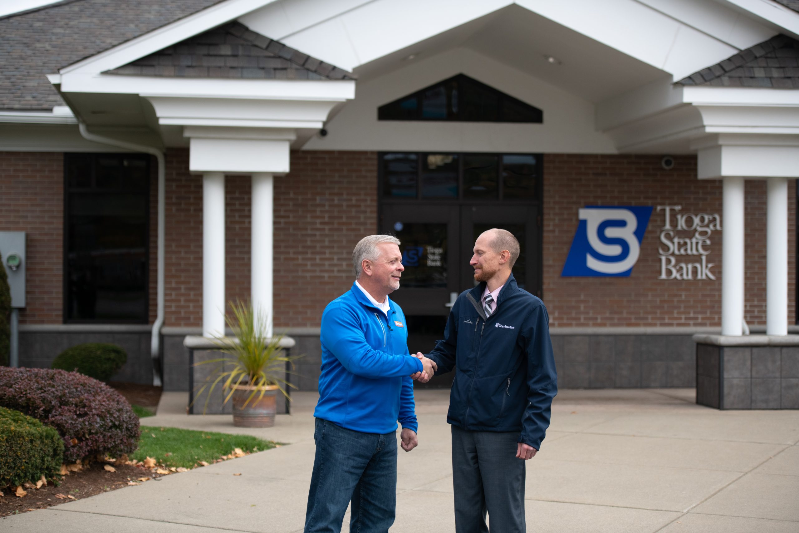 Jon Ward shaking hands with Mike Butler in front of TSB