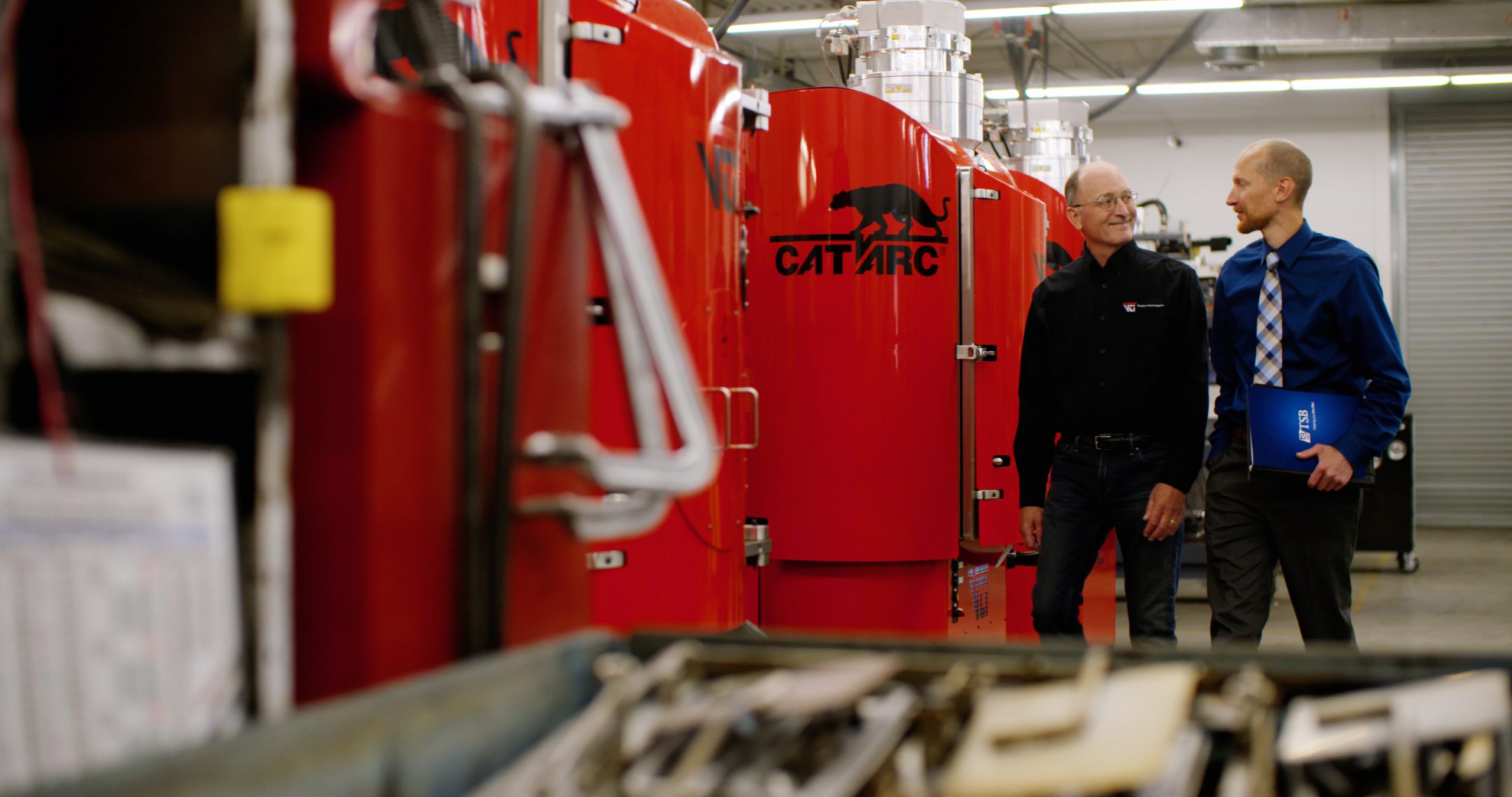 Gary with Jon walking by the red VTI machine